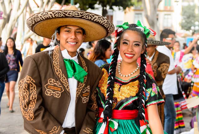 Review - Genealogy at a Glance: Mexico Genealogy Research 2 Image of a teen boy in a sombrero and a girl in colorful Mexican clothing at a fiesta.