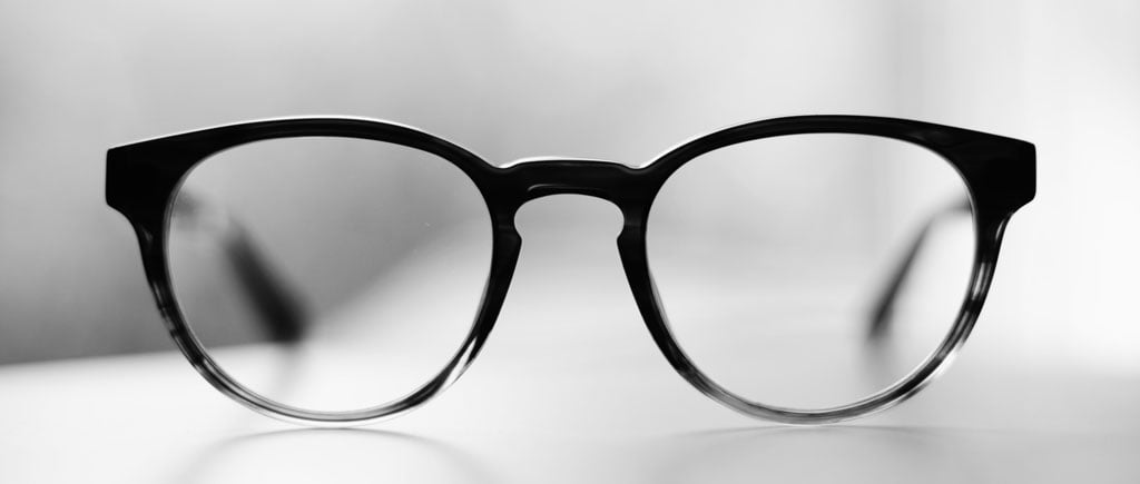 Accepting the One Word Challenge: Focus 2 Black framed glasses on a desk