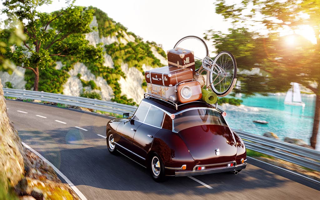 The Genealogy Blog Party: Research Trip - image of a car with suitcases piled on top driving on a scenic road.