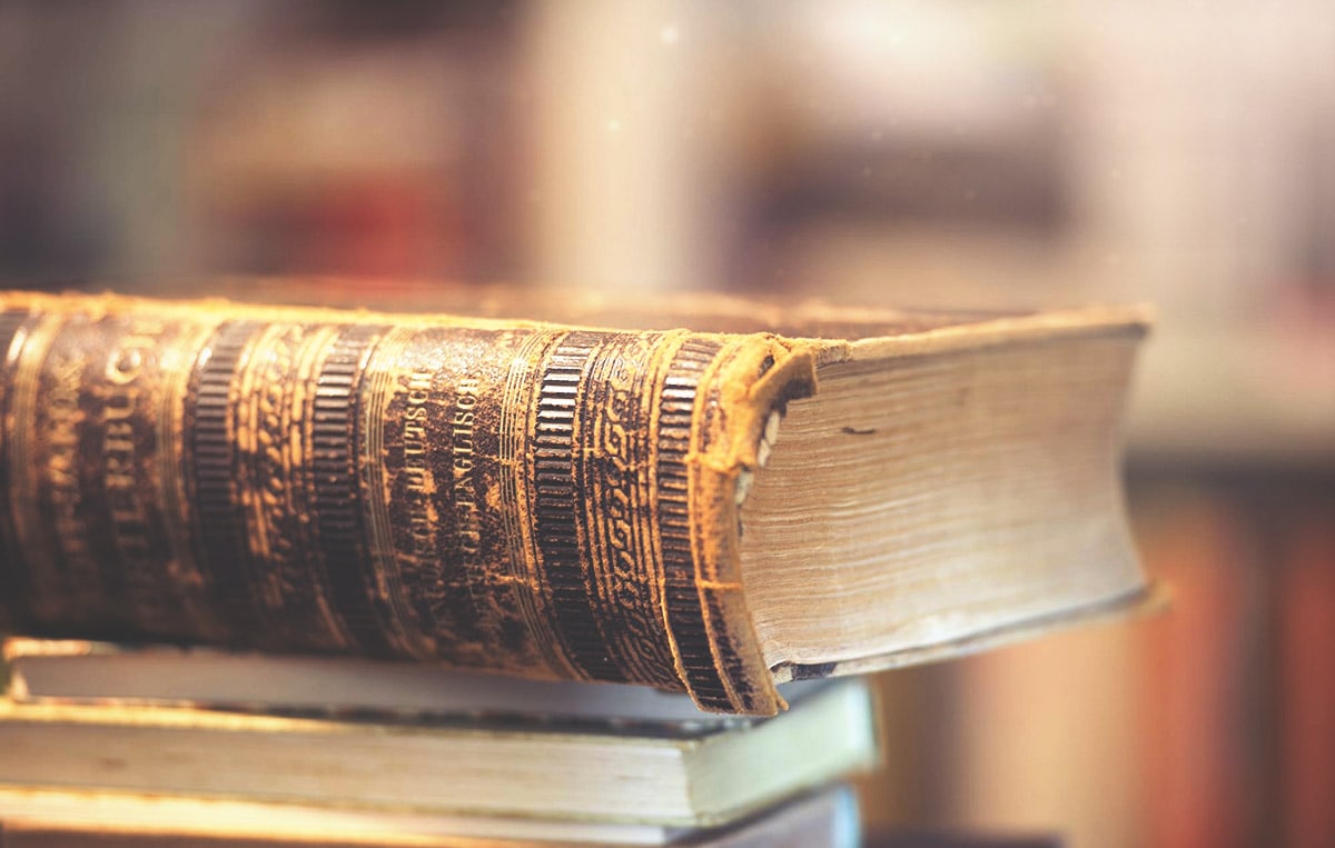 Image of an old Bible laying on a stack of books