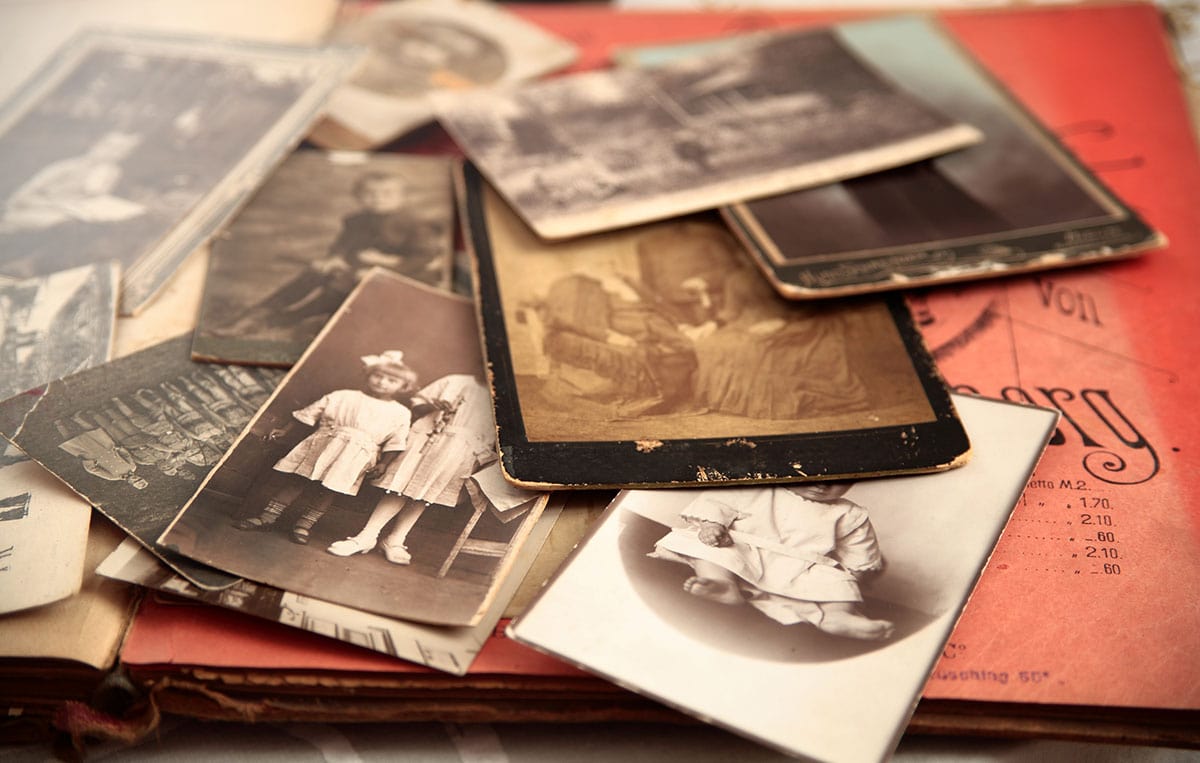 Featured image: a pile of old, sepia photos for Family History Month.