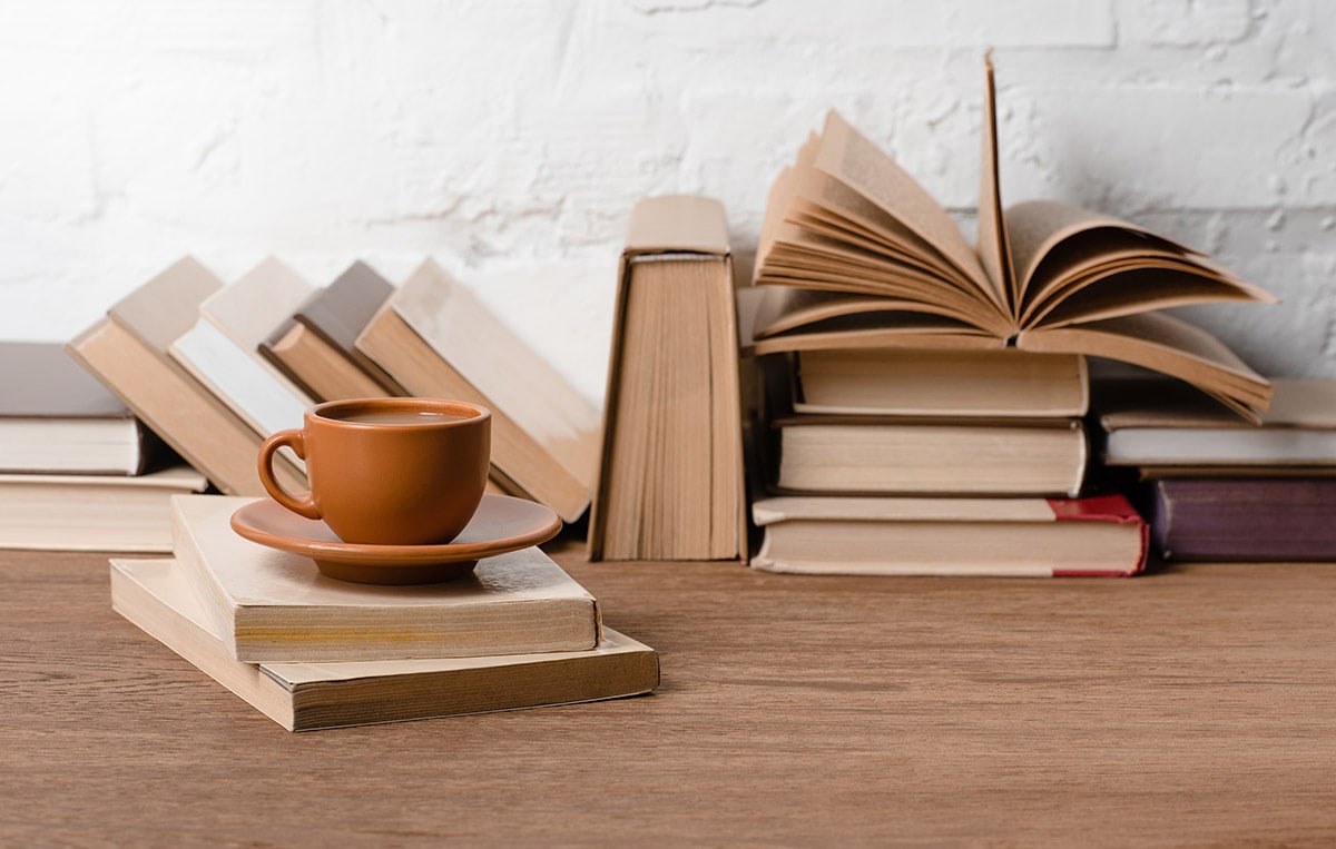 The Genealogy Blog Party: What You Learned - image of a brown coffee cup next to brown and beige books.