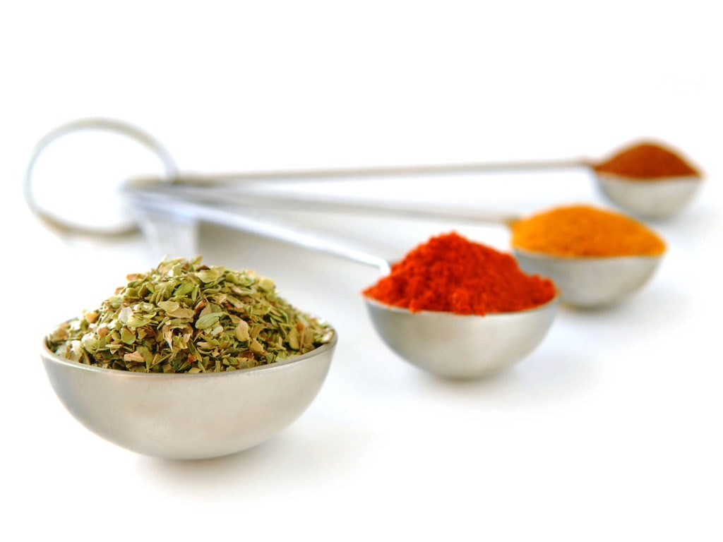 Turkey Meatloaf: An Update to a Mid-Century Classic Comfort Food 3 Image of green, red, yellow, and orange spices in silver metal measuring spoons.