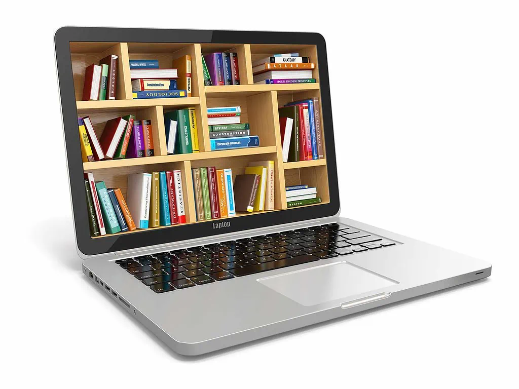 10 Best Strategies for Researching "Brick Wall" Ancestors 4 Silver and black laptop computer with dozens of books on shelves on the screen.