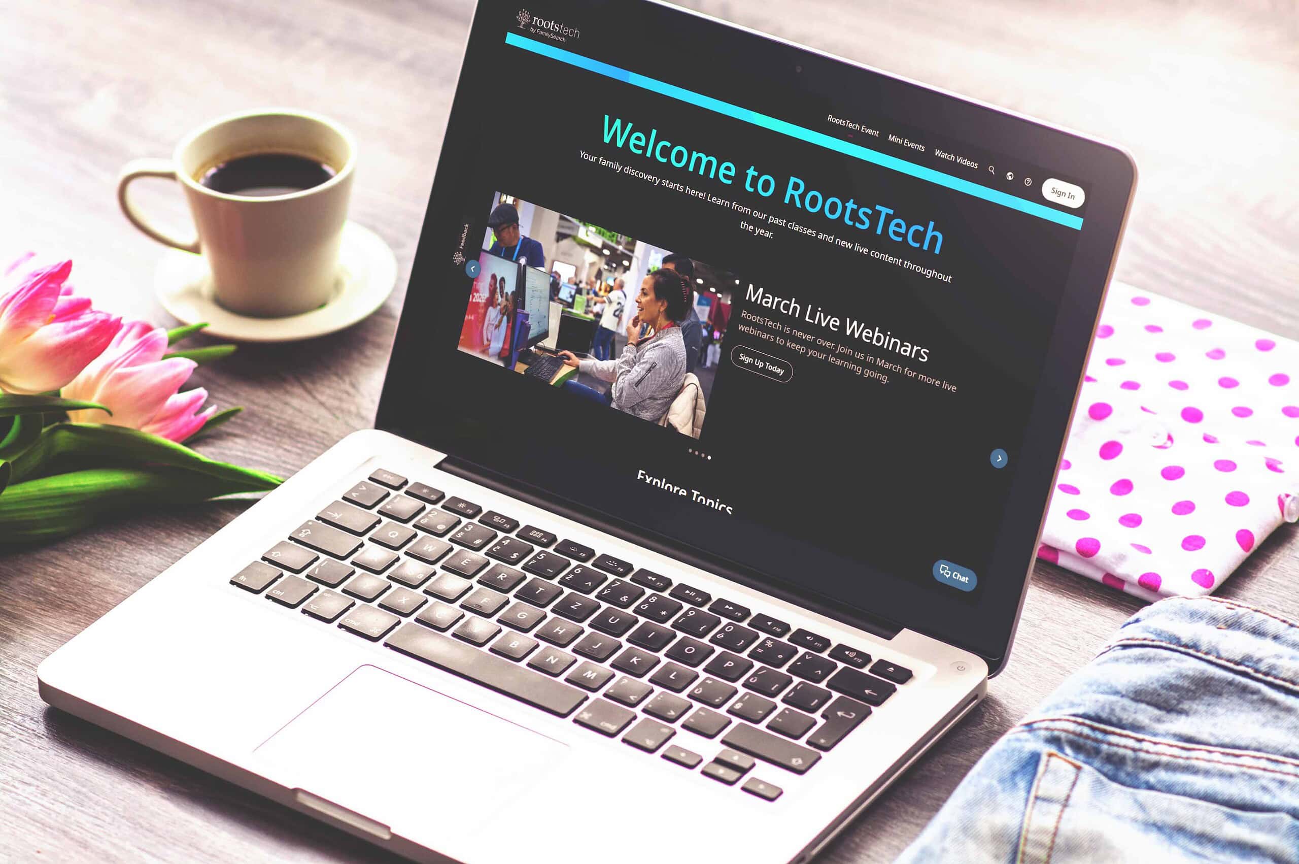 Laptop displaying RootsTech website with flowers