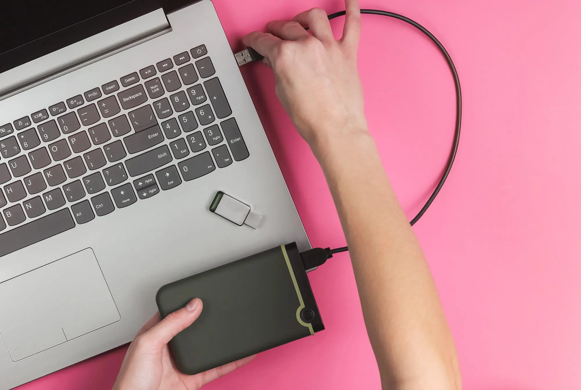 How to Record an Oral History Interview Before It's Too Late 5 a woman's hand plugging an external hard drive into a laptop computer