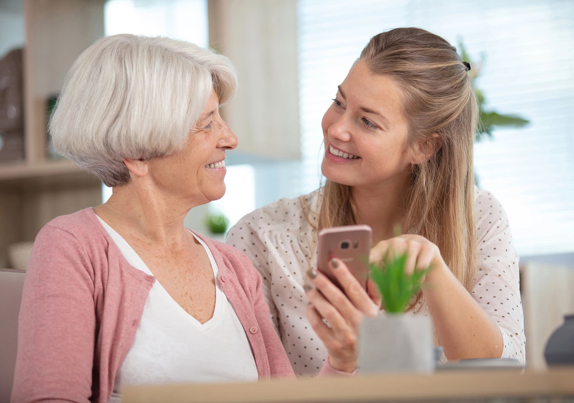 How to Record an Oral History Interview Before It's Too Late 4 Gray-haired woman and adult daughter looking at photos during an oral history interview
